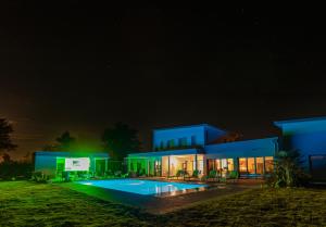 um grande edifício azul com piscina à noite em Domaine Georges V em Saint-Junien