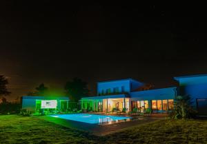 a large blue building with a pool at night at Domaine Georges V in Saint-Junien