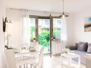 biały salon ze stołem i krzesłami w obiekcie VacationClub – Zdrojowa 22 Apartament 5 w Świnoujściu