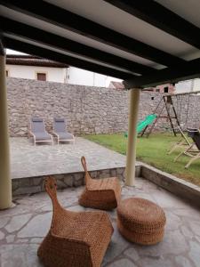 - 2 chaises et des chaises en osier sur la terrasse dans l'établissement EL JARDÍN DE ALEYDA, VV VACACIONAL, à Llanes