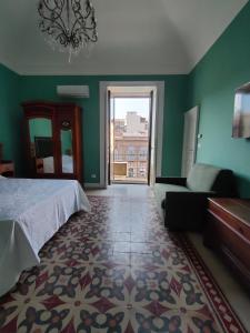 ein Schlafzimmer mit einem Bett, einem Sofa und einem Fenster in der Unterkunft Finestre in piazza in Catania