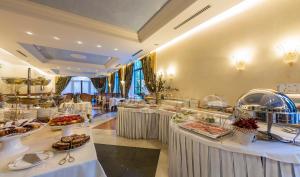una linea a buffet con tavoli pieni di cibo di Hotel 4 Stagioni Sensus Spa a Bardolino