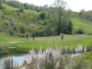 een groep mensen die golfen op een golfbaan bij Il Gelsomino in Castelfalfi