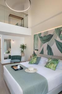 a bedroom with a large white bed with a green patterned wall at Mossa Well Being Hotel - Heated pool and Wellness Spa in Kato Daratso
