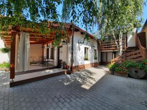 a house with a patio with a table and chairs at Korona Panzió in Odorheiu Secuiesc