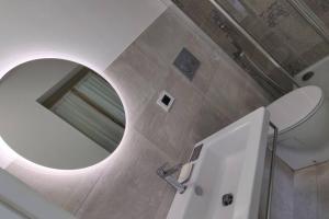 baño con espejo redondo y lavabo en LaCasetta, en Saint Vincent