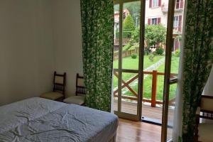 Schlafzimmer mit einem Bett und einer Glasschiebetür in der Unterkunft LaCasetta in Saint Vincent