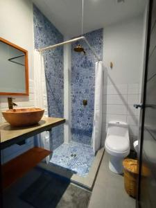 La salle de bains est pourvue de toilettes, d'un lavabo et d'une douche. dans l'établissement Alive Beach House, à Transito