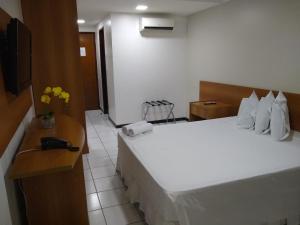 Habitación de hotel con 2 camas y teléfono en Ponta Negra Flats Partic, en Natal