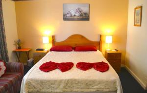 Un dormitorio con una cama con arcos rojos. en Palms Bed & Breakfast, en Perth