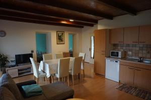a kitchen and dining room with a table and chairs at Apartment Pri Bricu in Kobarid