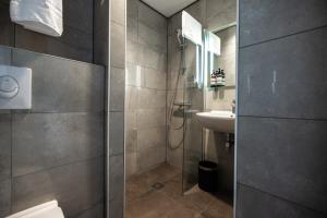 a bathroom with a shower and a sink at HOTELUX Amsterdam Airport Hotel in Hoofddorp +16 photos