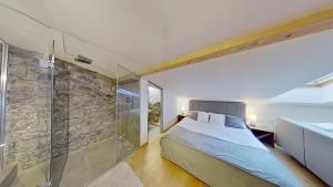1 dormitorio con cama y pared de piedra en Apartmán Pod Kalváriou, en Kremnica