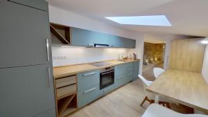 a kitchen with blue cabinets and a table with chairs at Apartmán Pod Kalváriou in Kremnica