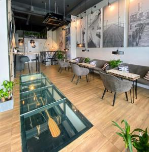 格地尼亞的住宿－Thruster - mini kino, lobby, kuchnia, netflix，配有桌椅和玻璃地板的客房