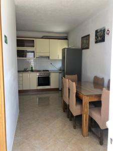 Apartment Ljubica Ljuban في ماكارسكا: مطبخ مع طاولة خشبية ومطبخ مع ثلاجة