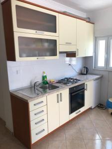 Apartment Ljubica Ljuban في ماكارسكا: مطبخ مع دواليب بيضاء ومغسلة
