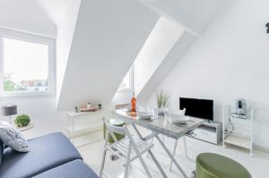 una sala de estar blanca con mesa y sillas en Le Petit Victor Hugo, en Montfermeil