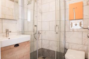 a bathroom with a shower and a toilet and a sink at Daphnis Hotel in Golturkbuku