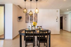 a dining room with a black table and chairs at The Smart Concierge - Bahar 1 in Dubai
