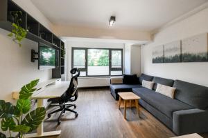 a living room with a couch and a desk at Modern Apartment in a Quiet Area in Cluj-Napoca