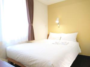 Postel nebo postele na pokoji v ubytování Smile Hotel Kobe Motomachi