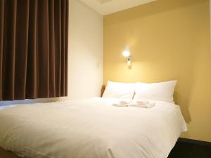 Postel nebo postele na pokoji v ubytování Smile Hotel Kobe Motomachi