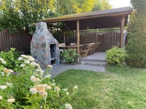 a picnic shelter with a stone oven in a garden at Willa Mare in Dębki