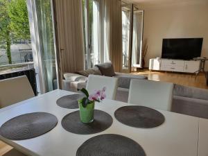 een woonkamer met een tafel met een vaas met bloemen erop bij SeWeR Apartment in Baden-Baden
