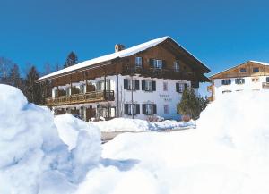 a house covered in snow with piles of snow at Landhaus Brigitte in Bad Bayersoien