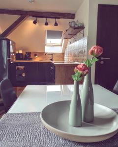 two vases with roses on a table in a kitchen at Apartmán Silvestr in Dolní Rychnov