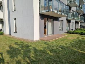 un immeuble d'appartements avec un balcon et une pelouse dans l'établissement Cozy Apartment in the city centre of Gdansk, à Gdańsk
