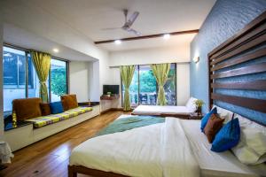 - une chambre avec 2 lits et une grande fenêtre dans l'établissement EKO STAY - Tropical Beach Apartments, à Mumbai