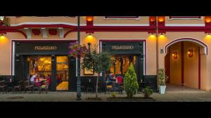 un restaurante con mesas y sillas frente a un edificio en Hotel Bulevard Sighisoara, en Sighişoara