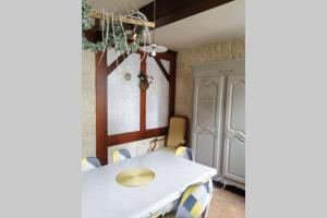 Escapade Normande في Yerville: غرفة طعام مع طاولة بيضاء وكراسي