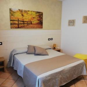 a bedroom with a bed and a painting on the wall at Agriturismo Pituello in Talmassons