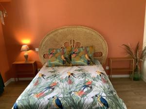 una camera da letto con un letto con sopra degli uccelli colorati di Jolie Appartement à la campagne a Hautesvignes