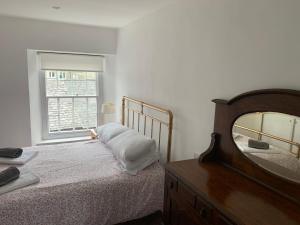 a bedroom with a bed and a mirror and a window at Stay with St Davids Kitchen in St. Davids