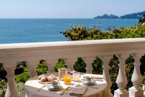a table with food on a balcony with the ocean at Excelsior Palace Portofino Coast in Rapallo
