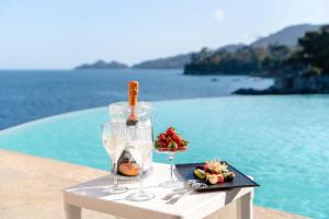 a table with wine glasses and a plate of fruit at Excelsior Palace Portofino Coast in Rapallo