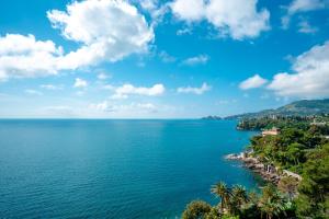 a view of the ocean with palm trees at Excelsior Palace Portofino Coast in Rapallo
