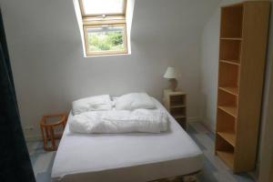 聖卡斯萊吉爾多的住宿－Agréable maison entre plage (900m) et forêt (600m)，一间卧室配有一张带白色床单的床和一扇窗户。