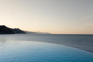 a swimming pool with the ocean in the background at Excelsior Palace Portofino Coast in Rapallo