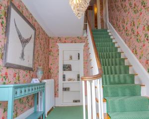 uma escada numa casa com carpete verde em Sally Webster Inn em Rockport