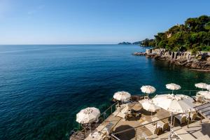 a group of umbrellas on a dock in the water at Excelsior Palace Portofino Coast in Rapallo