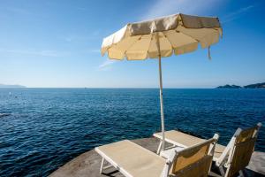 a table and chairs and an umbrella on a boat at Excelsior Palace Portofino Coast in Rapallo