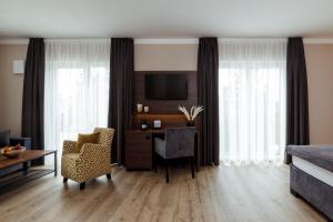 a living room with a desk and a bedroom at Herzl Hotel bei Erding in Forstern