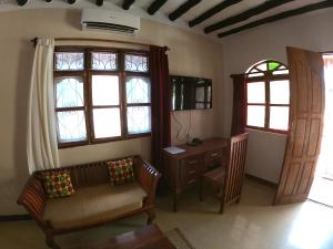 a living room with a couch and a desk and windows at Sunbrella Boutique Hotel in Michamvi