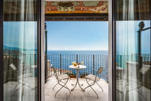 a balcony with a table and chairs and the ocean at Excelsior Palace Portofino Coast in Rapallo