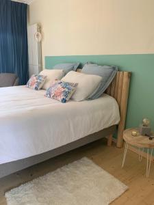 un letto con cuscini sopra in una camera da letto di Chambres des marais a Merville-Franceville-Plage